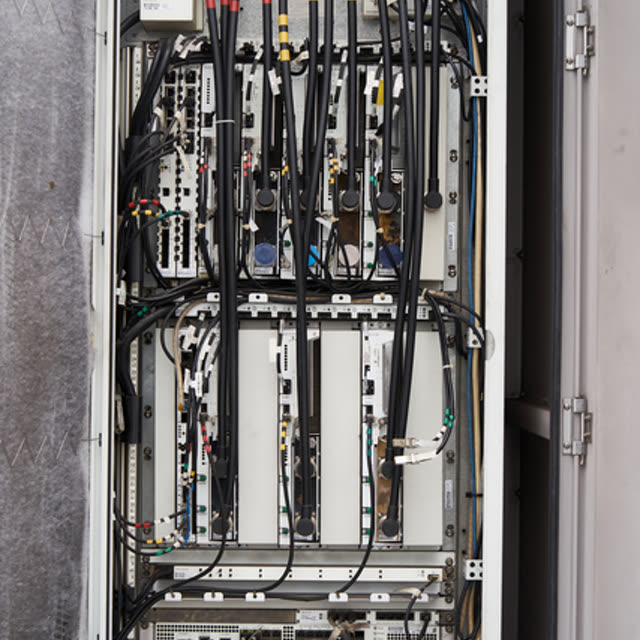 An open electrical control cabinet, densely packed with wiring and terminals
