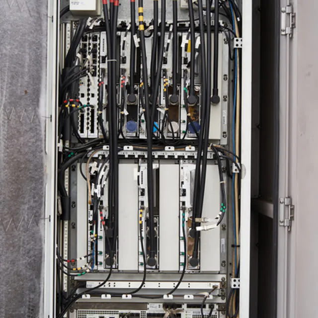 An open electrical control cabinet, densely packed with wiring and terminals