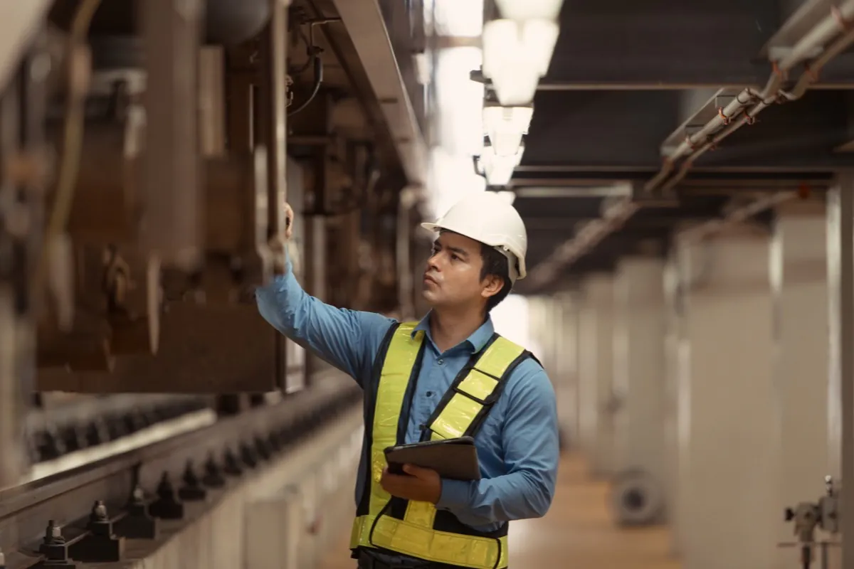 Thermographer scanning an energized switchgear cabinet with a handheld infrared camera