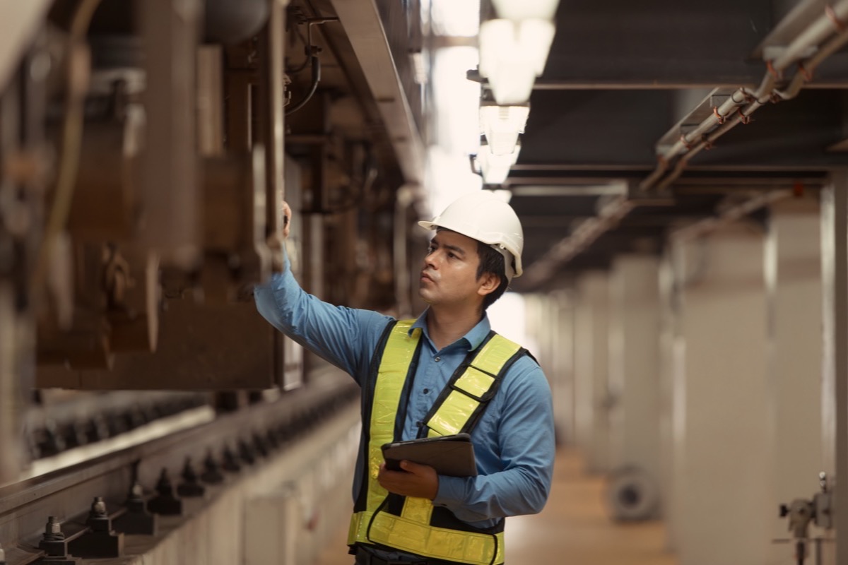 Thermographer scanning an energized switchgear cabinet with a handheld infrared camera